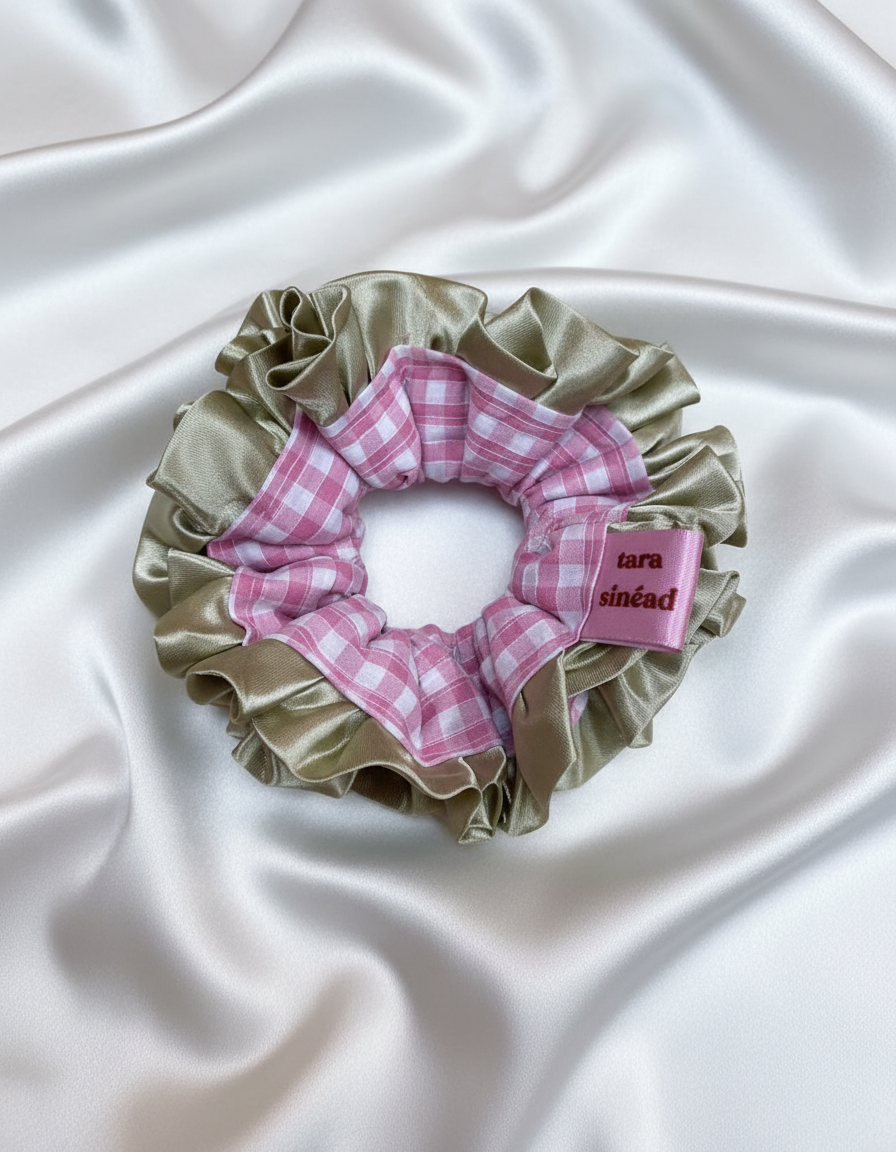 Pink checkered scrunchie with green border and 'tara sinéad' label on a white background